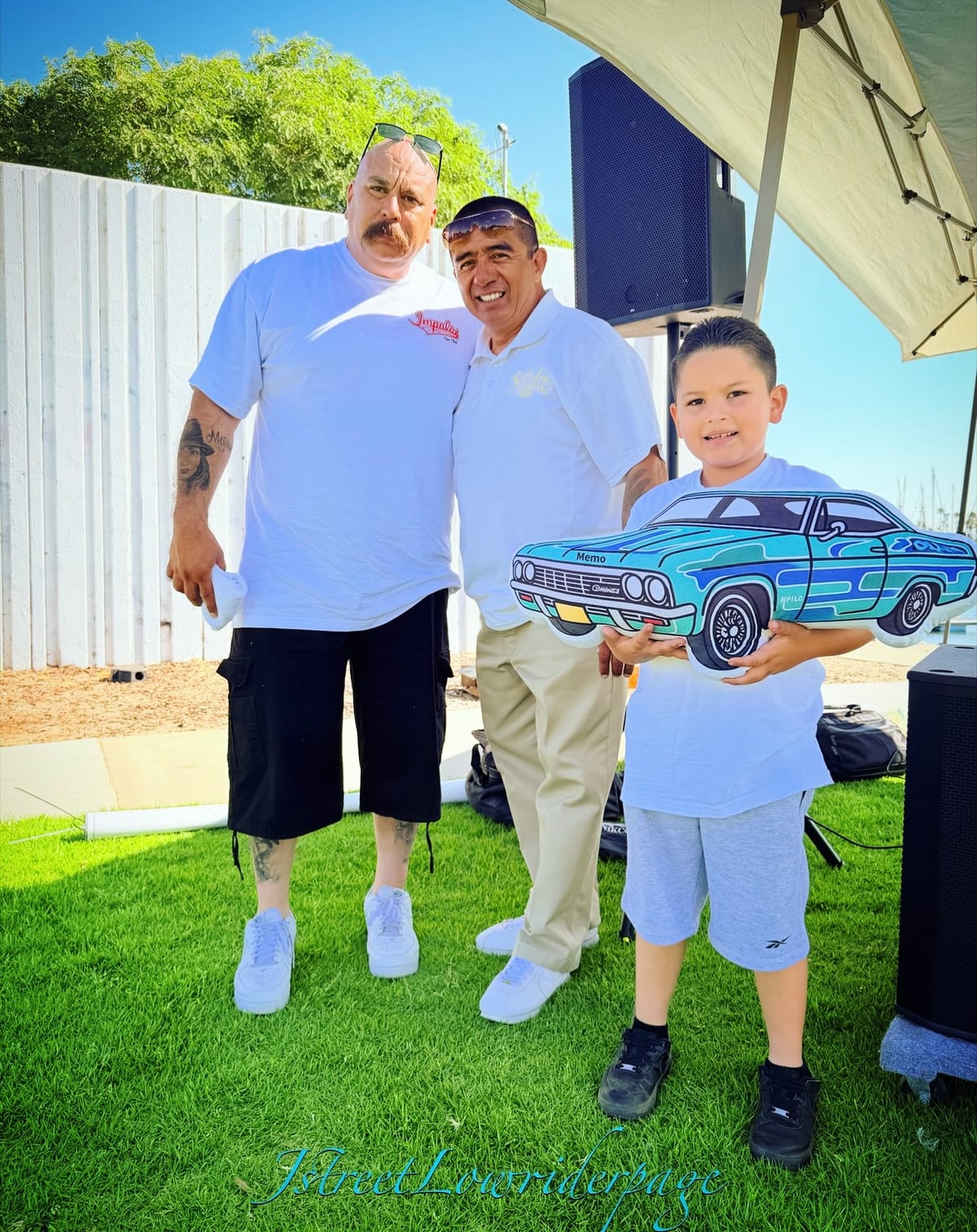 A child holds a custom car-shaped prize with adults at a Solida community gathering.
